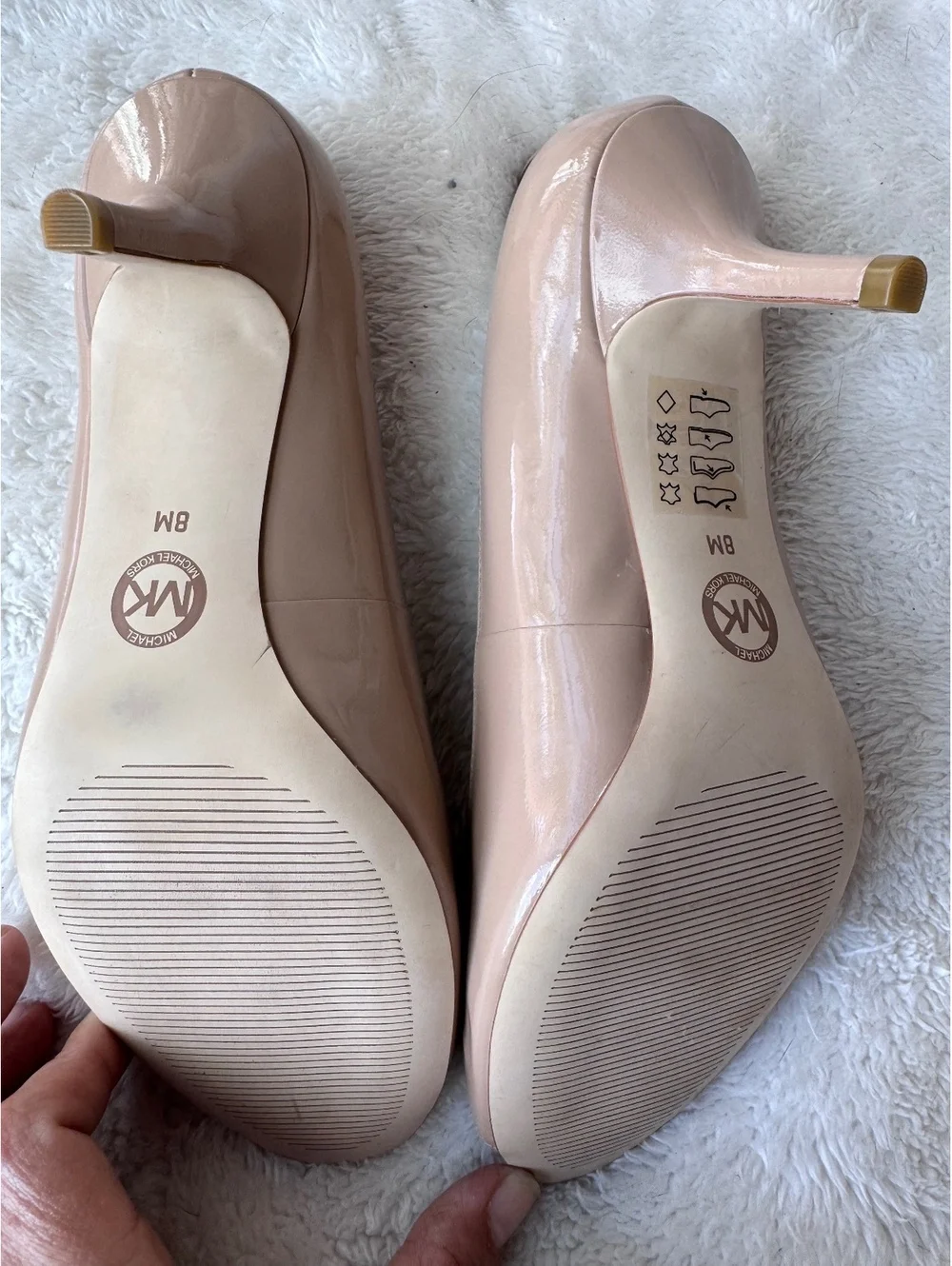 Michael Kors women’s patent leather peep-toe pumps in a classic nude/blush color